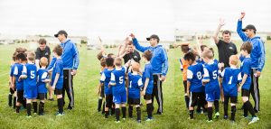 Young Soccer Team in Blue Jerseys cheering at end of game